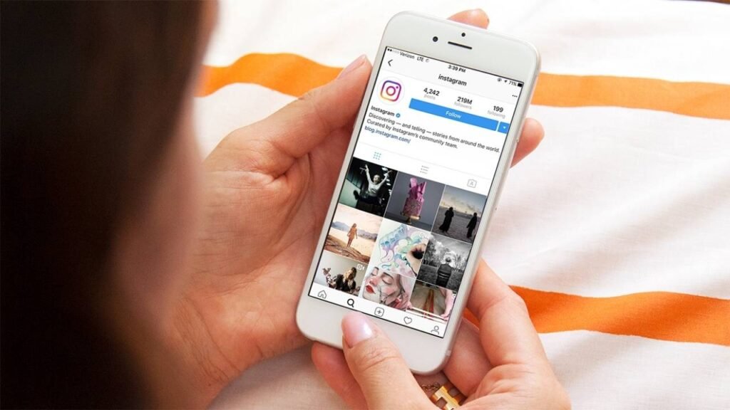 A person holding a smartphone while browsing the official Instagram profile, illustrating the concept of TTM meaning on Instagram.