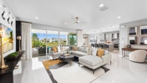 A bright living room featuring white tile flooring and a large television, showcasing Misha Ezratti’s journey with GL Homes.
