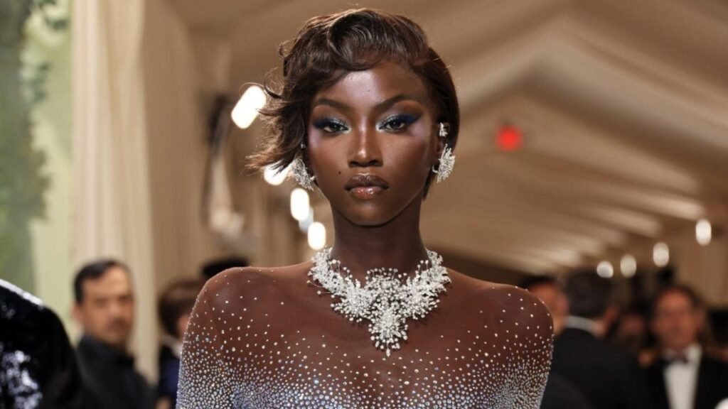Anok Yai wearing a glamorous diamond-studded dress and jewelry at a red carpet event
